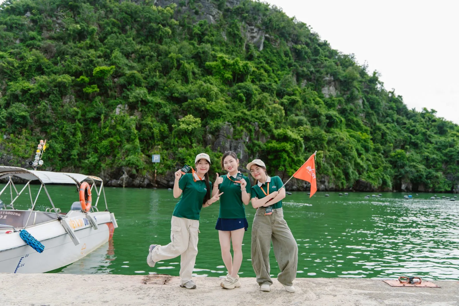 Ba hướng dẫn viên Avory bên mép nước, nền núi đá vôi Hạ Long